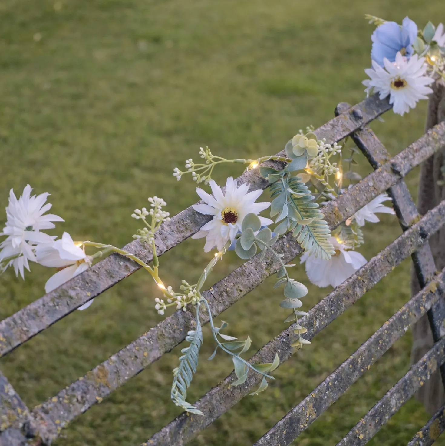 Beleuchteter Kranz und Girlande mit blauen und weißen Blüten