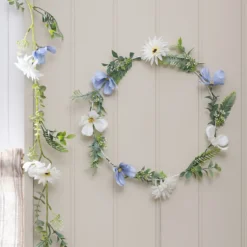 Beleuchteter Kranz und Girlande mit blauen und weißen Blüten