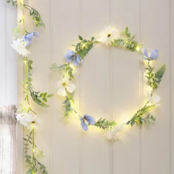 Beleuchteter Kranz und Girlande mit blauen und weißen Blüten
