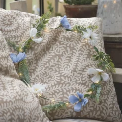 Beleuchteter Kranz und Girlande mit blauen und weißen Blüten