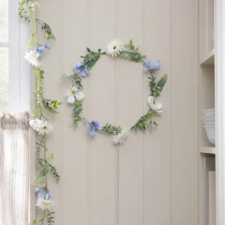 Beleuchteter Kranz und Girlande mit blauen und weißen Blüten