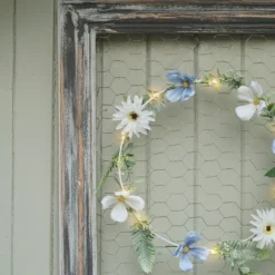 Beleuchteter Kranz und Girlande mit blauen und weißen Blüten